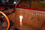 A mostly traditional interior, with a medium brown Naugahyde in rolls and pleats on stock frames. The dash and window sills are painted in simulated wood. Features a tilt column with Grant wheel, custom gauge panel and chromed glove box door.